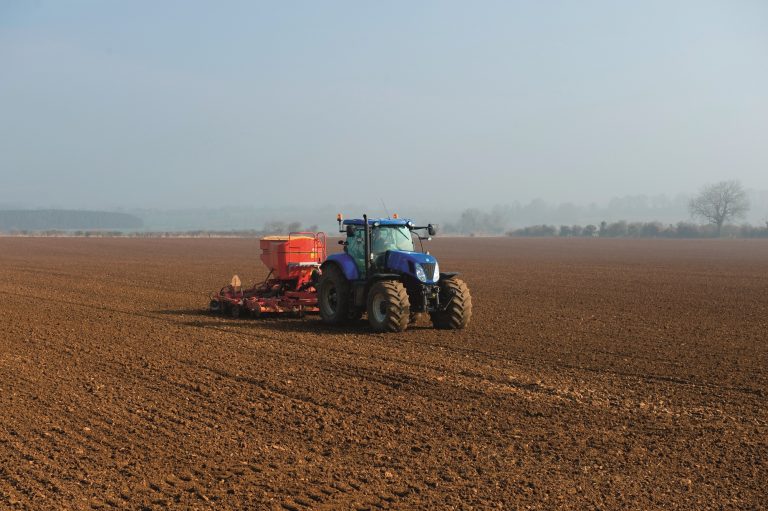 Gloucester, Gloucestershire, England, UK --- Tractor drilling seed in ploughed field on misty morning --- Image by © Henry Arden/Corbis